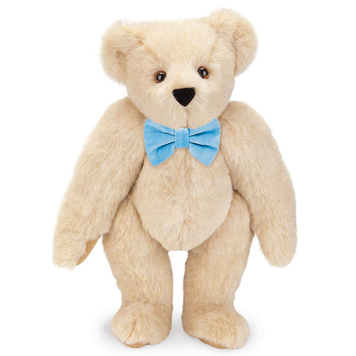 Honey-colored plush teddy bear with brown eyes and a light blue bow tie.