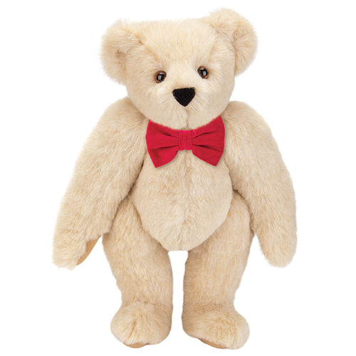 Cream-colored plush teddy bear with brown eyes and a red bow tie.